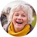 old woman with yellow scarf smiling