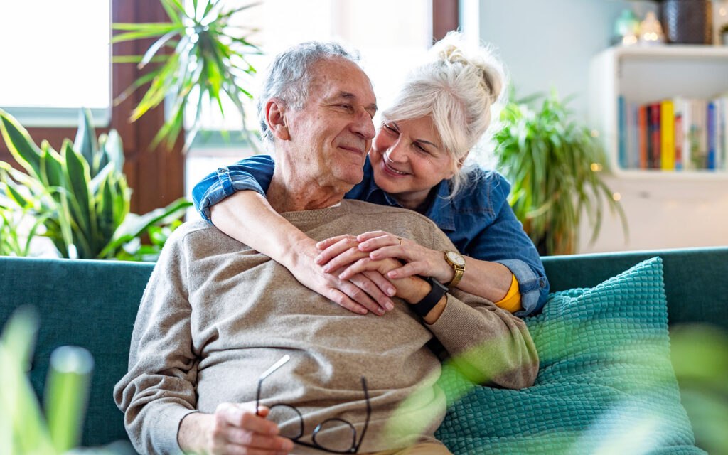 Senior couple smiling on a sofa