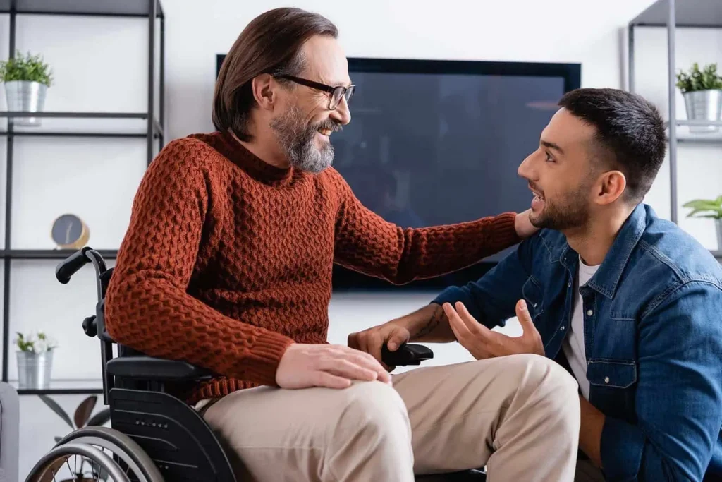 man in a wheelchair talking with a younger man