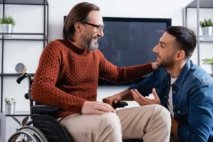man in a wheelchair talking with a younger man