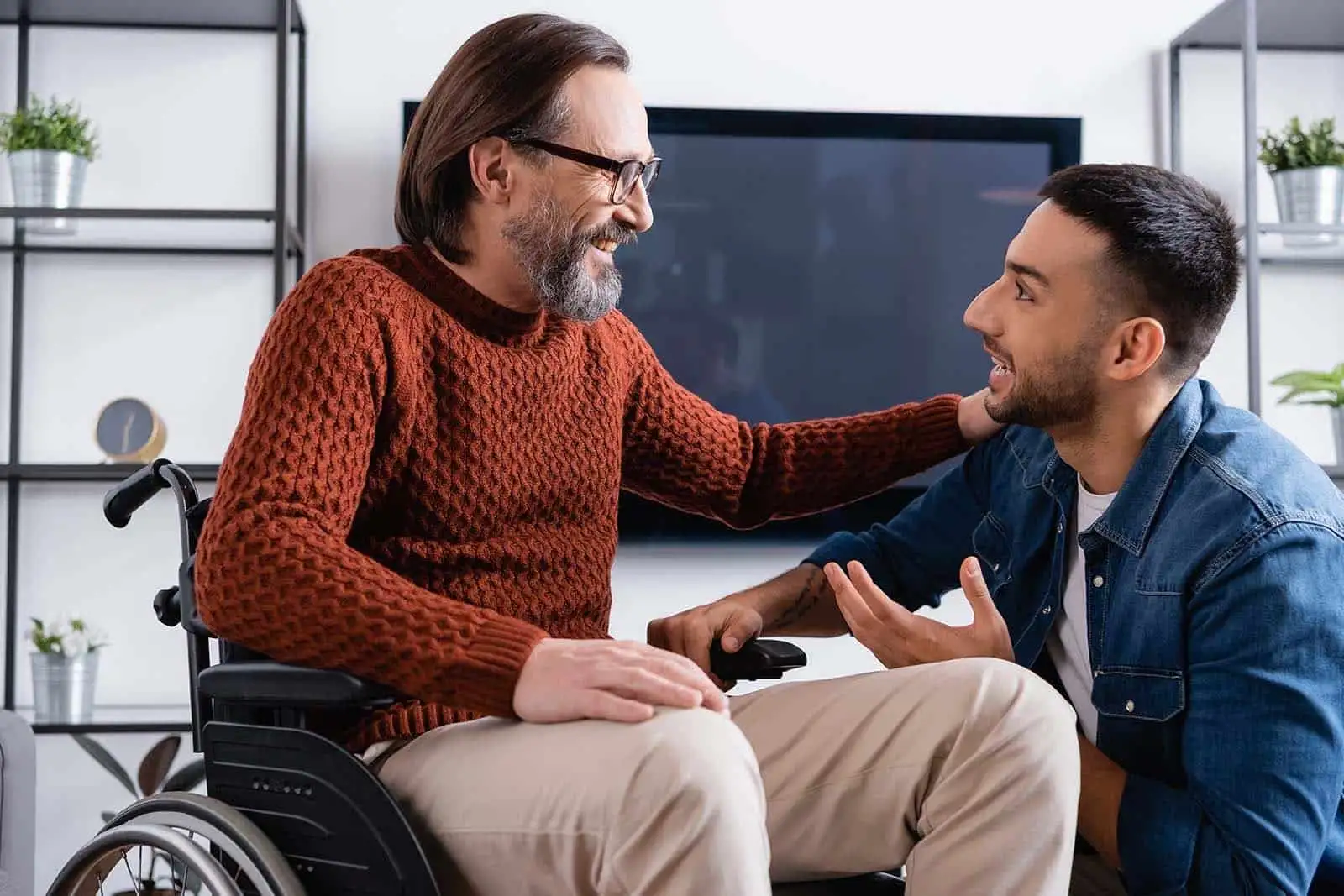 man in a wheelchair talking with a younger man