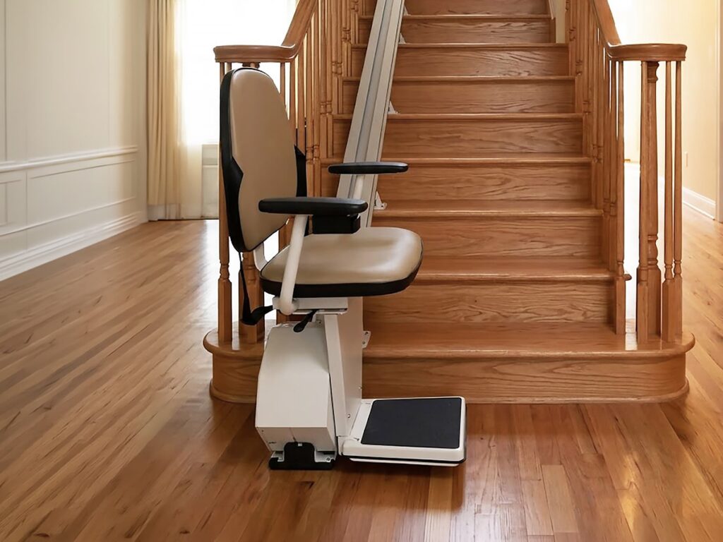 white indoor stairlift waiting at the bottom of a wood staircase
